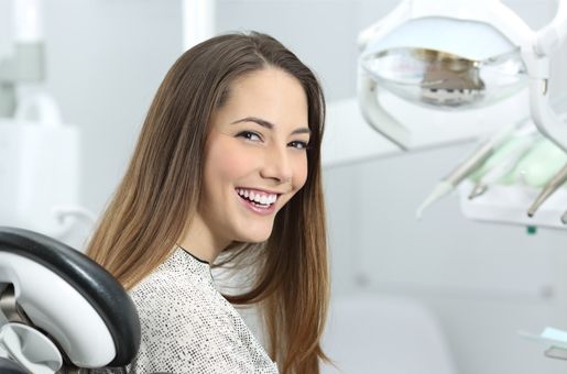 brunette woman smiles in dental chair 