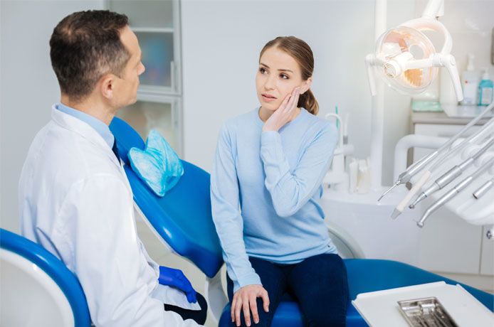 woman consults with dentist in office 