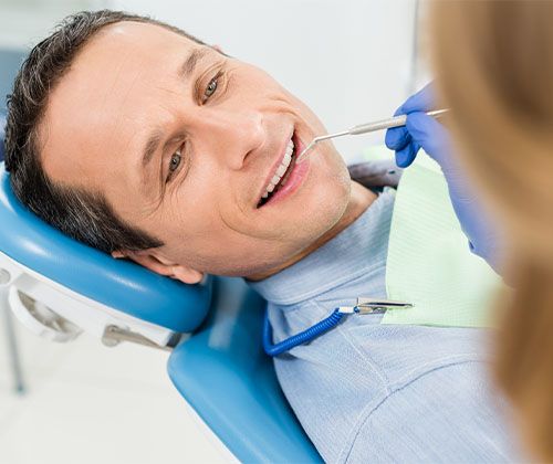 man receives a dental examination by dental assistaint 